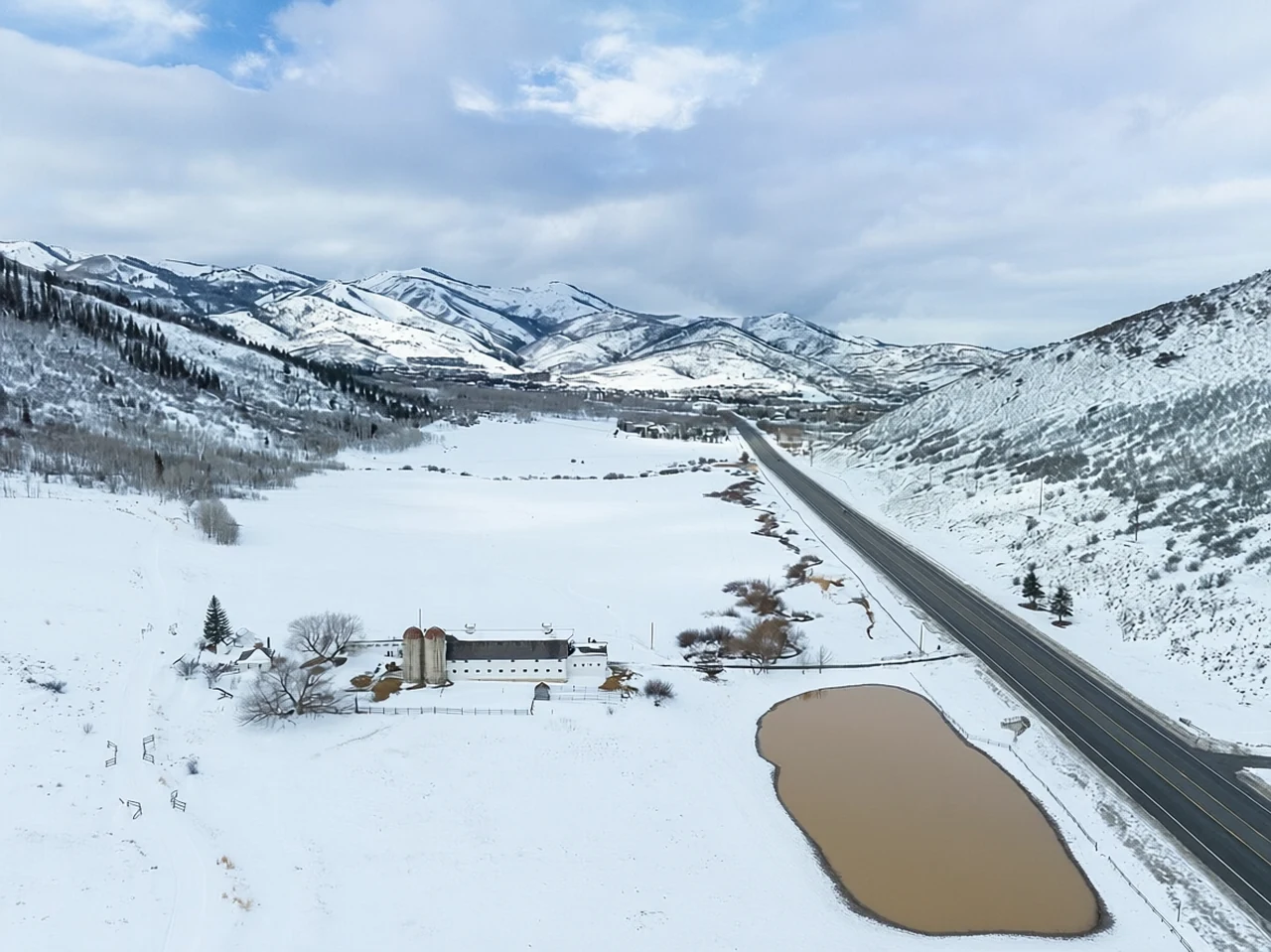Snowmelt flooding beside a mountain road at Snowy Utah mountain corridor, generated by our world model